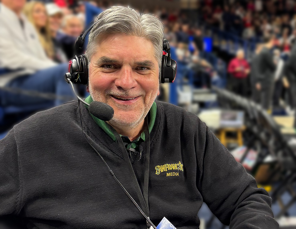 announcer pat olson at a game. he is wearing a headset with mic